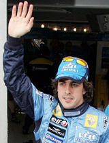 Formula One driver Fernando Alonso of Spain waves to the crowd after taking the pole position of the French Grand Prix at the Magny Cours circuit