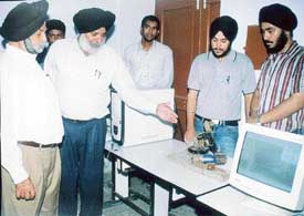 Prof Avtar Singh, Chairman of Sri Sukhmani Institute of Engineering and Technology, inspects a PC-controlled robotic arm developed by students