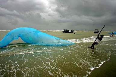 A fisherman adjusts his net against the backdrop of monsoon clouds at Sagar Island, the confluence of the Ganga and the Bay of Bengal, about 150 km south of Kolkata, on Sunday.