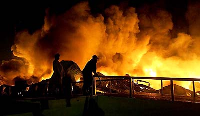 Firemen fight a fire at a lubricants manufacturing terminal in Karachi on Sunday