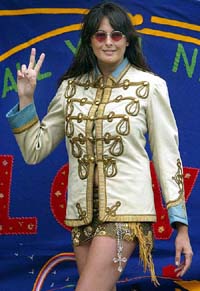 Louise B. Cooper, Director of Cooper Owen auction house, at a press preview in central London, on Monday, wearing the military band tunic that was worn by John Lennon during the classic 1966 Life Magazine Henry Grossman photo session when the The Beatles revealed their new look. 