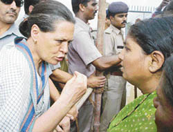 UPA Chairperson Sonia Gandhi talks to a flood-affected woman in Vadodara on Monday. 