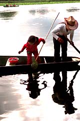 other and daughter fish for river snails at a lake at Puzhehei township in southwest China's Yunnan province on Monday