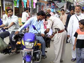 Police personnel frisk a motorcylist in Varanasi on Tuesday after an unsuccessful militant attack on a temple in Ayodhya. 