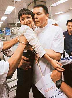 Muhammad Ali is greeted by a child on his arrival at the Singapore airport on Monday