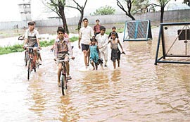 The approach road to the civil airport and the parking lot on the left adjoining the security wall of the Air Force Station submerged under rainwater in Chandigarh on Tuesday.