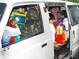 School students packed like sardines in a van.
