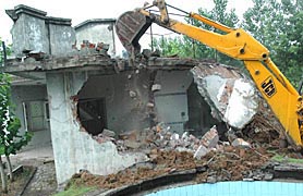 A JCB machine pulls down a farmhouse in Kishangarh village in Chandigarh.