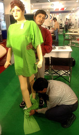 Workers dress up a mannequin at the ZAK Garmentech International, 2005, fair at Pragati Maidan in Delhi on Thursday.