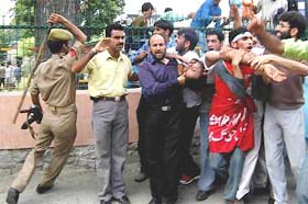 Jammu and Kashmir police jawans cane-charge protesting teachers while an injured teacher is being carried by other teachers, demanding confirmation of their services, in Srinagar