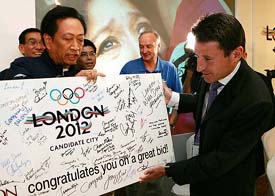 Londons bid leader and former Olympic champion Sebastian Coe receives a congratulatory placard after a press conference in Singapore on Thursday after London won the right to host 