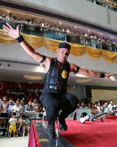 Peter Rosendahl of Sweden rides the world's smallest unicycle during a demonstration at a shopping mall in Hong Kong on Friday.