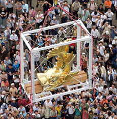 Japanese spectators watch a golden dolphin ornament being lifted to the roof of seven-storeyed Nagoya Castle located in the central Japanese city of Nagoya on Saturday 