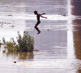 A child about to test the swollen waters of river Yamuna near ITO in the Capital on Saturday.
