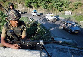 Border Security Force men guard a section of the Jammu-Srinagar National Highway near Nandnai, as vehicles carrying Amarnath pilgrims make their way to base camp, on Saturday.