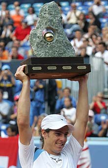 Gaston Gaudio of Argentina holds the trophy after winning the final of the Swiss Open ATP tennis tournament against Stanislas Wawrinka of Switzerland in Gstaad on Sunday. Gaudio won 6-4, 6-4 to clinch his fourth title of the season.