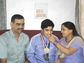 Wrestler Geetika Jakhar with her parents in Hisar on Monday