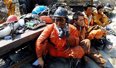 A Chinese rescuer calls those inside a coalmine pit to get the latest news of the rescue mission at the Shenlong coalmine in Fukang county, northwest Chinas Xinjiang Autonomous Region, on Monday