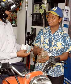 A woman handing over a sapling to a customer at Bharat Petroleums all-woman outlet on Shanti Path in the Capital