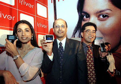 Former Miss India Manpreet Brar, vice-president of Reigncom, Henry Kimand, Managing Director of Salora International, Gopal Jiwarajka, display a range of portable digital audio-visual devices during a launch in New Delhi on Saturday. 
