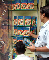 A shopkeeper arranges rows of Harry Potter and the Half-Blood Prince in a showcase in New Delhi.