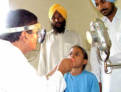 A doctor extracts a foreign item from the throat of Indu Kaur at Civil Hospital, Bathinda, on Saturday.