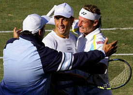 Argentinas David Nalbandian and his partner Mariano Puerta celebrate with team captain Alberto Mancini after winning their doubles match against Australias Lleyton Hewitt and Wayne Arthurs