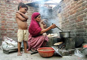 Pakistani Naseen, wife of Nazir Ahmed Cooke, cooks a meal at her home