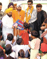 Punjabi singers Daler Mehndi, Shankar Sahni and Ashu Punjabi distributing schoolbags to poor children at a function of National Akali Dal at Mansarovar Garden in the Capital on Sunday.