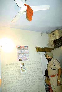 DSP S.S. Randhawa inspects the suicide note written on the wall of a Sector 45 house in Chandigarh