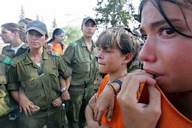 Young Israelis, opponents to Israeli Prime Minister Ariel Sharon's disengagement plan, cry as they stand in front of Israeli border policewomen