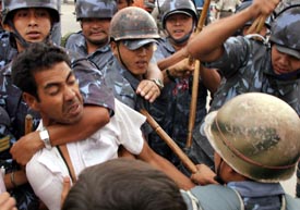 Nepali policemen arrest an agitating political activist belonging to the student wing of seven political parties at New Baneswar, in Kathmandu