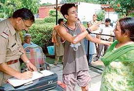 Gaurav narrates the chain snatching incident to a policeman in Sector 23 in Chandigarh on Wednesday. Also seen in the picture is Reeta (extreme right)
