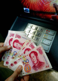 A customer checks hundred yuan bank notes at an ATM in Beijing on Thursday. China scrapped the yuans peg to the US dollar on Thursday and tied it to a basket of currencies as the first step in highly anticipated reforms aimed at letting the currency float freely. The new yuan rate versus the dollar revalues the currency by 2.1 per cent, to 8.11 per US dollar as on 1100 GMT