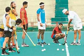 Chief coach of the Indian hockey team Rajinder Singh (Jr.) (extreme right) gives tips to players during a national camp held at the Sector-42 Stadium in Chandigarh on Thursday. 