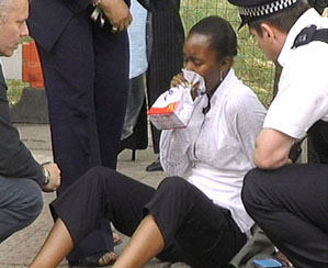 A woman is assisted by men of the emergency services outside Shepherds Bush train station after the station was evacuated in west London on Thursday.