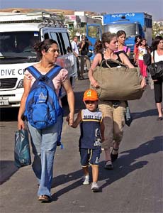 Tourists carry their belongings as they leave a hotel in the Red Sea resort of Sharm el-Sheikh in Egypt