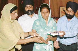 Visually impaired Rajvinder Kaur of BA (II) gets a prize from members of the managing committee of Ramgarhia Girls College in Ludhiana on Saturday