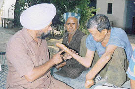 Mr Prem Singh Bhutte, a national award winner, with a leprosy affected person at Khanpur village near Sirhind.