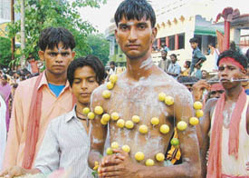 Devotees of Mariamma with their cheeks pierced and lemons stitched on the abdomen in Ludhiana