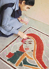 A student takes part in the rangoli competition organised by Baba Isher Singh School in Ludhiana
