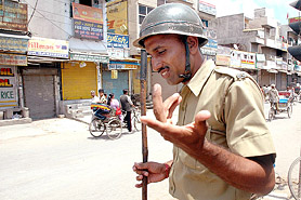 A Haryana policeman patrols in a market during a general strike called by the Left wing parties in Gurgaon on Thursday. 