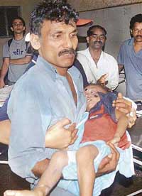 A family member carries out an injured child from Mumbai's Kooper Hospital on Friday after a tsunami scare caused a stampede in the Nehru Nagar slums of Mumbai on Thursday night.