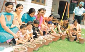 Students of Small Wonders Pre-Nursery and Nursery School get help from their parents to plant saplings at a function in the school on Friday