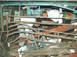 Forensic experts inspect the ripped portions of a commuter train in which a bomb blew up, at Jaunpur town, 130 km northwest from Allahabad.