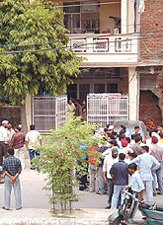 People gather outside the scene of a shoot-out at Mansarover Garden area in the Capital on Saturday.