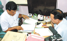 CBI officers inspecting documents in the office of Srichand, a Housing Committee businessmen based in Mayur Vihar, during their raids in various part of Delhi in the Capital on Monday. 
