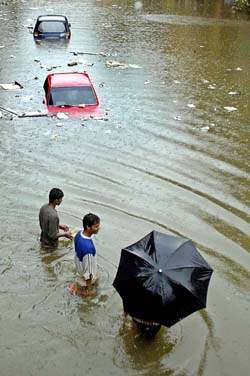 People wade through a waterlogged street in Mumbai on Monday.