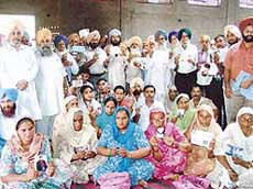 Relatives of Punjabi youths lodged in Pakistani jails show their photographs in Moga on Monday.