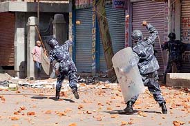 Riot police personnel throw back brickbats at college students during a demonstration against the arrest of student leaders and the sentencing of former Prime Minister Sher Bahadur Deuba, in Katmandu on Monday
